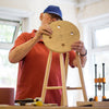 Man in a workshop holding a wooden stool