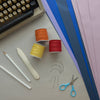 scissors, thread, typewritter, white penicl, white folding bone, paper, some needles
