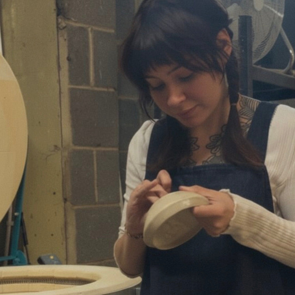 Person working with pottery in a studio setting