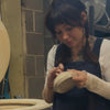 Person working with pottery in a studio setting